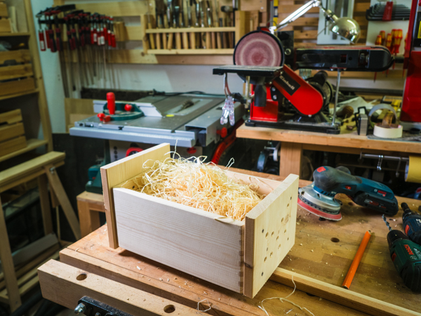 Kasten mit Holzwolle befüllen